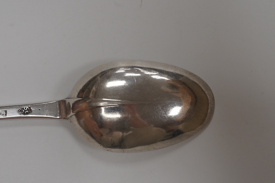 A Queen Anne silver dog nose basting spoon, with rat tail bowl, by William Scarlett, with engraved dated armorial to the terminal, London 1708, 32cm length, 95g. Condition - poor to fair